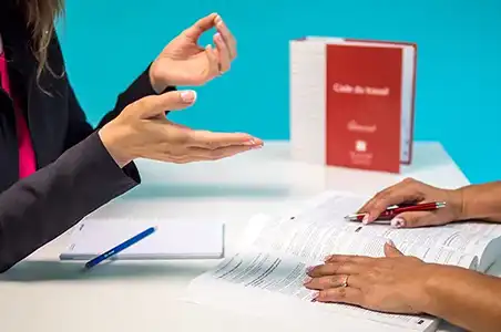 Le service Audit de 2SE Conseils repose sur une écoute des besoins et le respect de la législation. Deux personnes autour d'un bureau suivent les textes officiels
